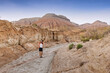 © EdNurg - Woman with backpack and hat enjoying a sunny day hiking in a sandstone canyon exploring rock formations