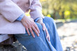 © Liubomir - Senior woman experiencing knee pain outdoors, sitting on bench