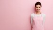 © Chandlerlikes - Positive female baker standing isolated on pink background, apron on, smiling with pure delight.
