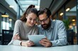 © starush - Woman and man using a tablet together in a modern indoor setting