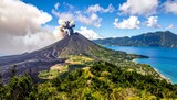 An active volcano erupts on a tropical island, with a plume of smoke rising against a bright blue sky, and a calm sea