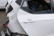 © ArieStudio - The rear of a white car shows severe collision damage, with the bumper and hatch completely mangled and detached. The destruction confirms a major accident and indicates a total insurance loss.