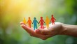 © Vadym - Hand holds colorful paper people chain, symbolizing unity and diverse community support. Group connects in a circle, representing teamwork and belonging.