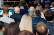 © tsuguliev - Audience at the modern conference hall listens to panel discussion, people on a congress together listen to speaker on stage at convention, plenary session at business seminar, venue for presentation