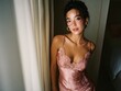 © Chanawat - Beautiful young woman in a silky pink slip dress, illuminated by warm sunset light, posing gracefully indoors.