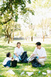 © Nuttapong punna - Joyful family volunteering to clean up a green park together. A positive lifestyle scene promoting eco-awareness, teamwork, and love for nature.