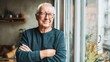 © Johannes - portrait of happy retired senior man standing at home near window satisfied old man looking at camera and smiling while standing near the window positive and confident elderly enjoy his retirement no