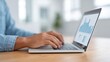 © 69 - Focused Employee Analyzing Financial Data on Laptop in Bright Modern Office Environment