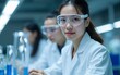 © feng - Young Chinese woman scientist wearing safety glasses working in a modern research laboratory. Advanced scientific and pharmaceutical laboratory for the development of medicine and biotechnology