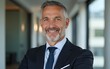 © handong - Happy mid aged older business man executive standing in office. Smiling 50 year old mature confident professional manager, confident businessman investor looking at camera, headshot close up portrait.
