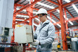 © DG PhotoStock - Engineer checking control panel in factory, updating software with tablet.