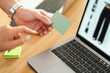 © Studio Marmellata - A person holds a payment card over a laptop, ready to make an online purchase.