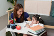© itchaznong - Engaging Homework Session: Mother and Daughter in Study Space