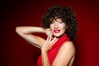 © Westend61 - Beautiful woman with curly hair wearing red lipstick in studio