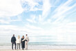 © kichigin19 - Group of friends 4 people on the background of blue sky and sea copy space background, view from the back