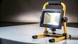 © Pitipat - Yellow and black work light on stand isolated on white background with bright illumination effects