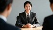 © Evans - Confident smiling Asian woman at a job interview. Young female candidate in a business suit meeting with recruiters. Professional career, employment and successful hiring concept.