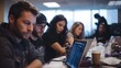 © Thares2020 - A diverse team of professionals collaborates intently around a table working on their laptops in a modern office setting