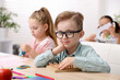 © New Africa - Cute children at wooden desk during lesson in elementary school