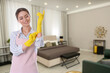© New Africa - Chambermaid with cleaning gloves in hotel room