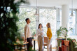 © we.bond.creations - Diverse coworkers collaborating and talking in a modern office, enjoying a casual break with natural light and plants