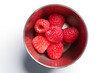 © Pavel Iarunichev - Fresh raspberries in metallic bowl on white tabletop. Nutritious juicy red berries. Top view