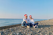 © Caterina Trimarchi - Two girlfriends middle aged women wearing santa hat spending time in the beach.
