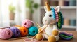 © GFX - Handmade Crochet Unicorn Toy with Colorful Yarn and Knitting Needles on Wooden Table image photo