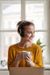 © Halfpoint - Young female student with headphones sitting at the table and studying.