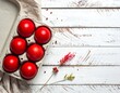 © Areptuwak - Overhead shot of six dyed red eggs in a cardboard carton, with flower and fabric on a white, weathered wood surface