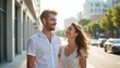 © Viktor - Happy young couple walks along city street enjoying sunny day. Smiling man, woman look at, laughing together. Lovers stroll outdoors on romantic date, showing connection, strong relationship.