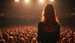 © Maryna - Woman speaker addresses large audience in theater with passionate, engaging talk. Red-haired woman in dark dress, spotlighted on stage, gesticulating with hands. Energetic, confident pro presentation