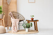 © Pixel-Shot - Interior of light room with wicker armchair, folding screen and plants