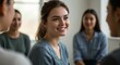 © Cintia - A young woman with a ponytail smiles brightly during a meeting in a light-filled space.