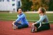 © djile - Women friends stretching on running track together