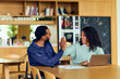 © bnenin - African-American Man And African-American Woman Celebrate High Five During Collaborative Office Meeting