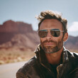 © SolaruS - Confident man with aviator sunglasses, leather jacket, in desert. Road reflection. Symbol of adventure, freedom, rugged style. Great for travel, fashion.