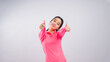 © Daniel - Asian woman in a bright pink long-sleeve sports shirt and black shorts standing confidently against a plain white background, smiling and showing a thumbs-up gesture straight toward the camera