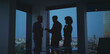 © Videophilia - Business team collaborating on strategy during an evening meeting in a modern office with city skyline view, silhouettes of executives planning and discussing a project