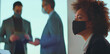 © Videophilia - Attentive businesswoman in black protective face mask and professional attire attending a corporate meeting with colleagues, practicing safety and social distancing during pandemic