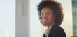 © Videophilia - Young professional african american businesswoman smiling with a natural pose, looking at the camera indoors, symbolizing confidence, success, and a friendly attitude in the workplace