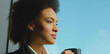 © Videophilia - Thoughtful young adult woman with afro hair drinking coffee and looking out a window, enjoying a moment of peace and contemplation under bright natural light