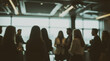 © Dmytriy - A blurry image of a group of people chatting at a business event in a modern office, with natural light coming from the windows. Ideal for business-related backgrounds or illustrations