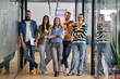 © .shock - Group of young business team walking together through a modern office hallway, smiling and discussing work. Concept of confidence, teamwork, leadership, and positive workplace culture.