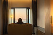 © shine - Work-Life balance. Happy relaxed calm beautiful lady enjoying comfort thinking good sitting on a couch looking through a window Colorful sunny sky clouds view, Calm peaceful sea waves positive energy.