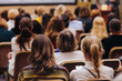 © tsuguliev - Female audience at the symposyum meeting, participants attendees in conference room hall listens to lecturer, group of women on a medical congress together listen to speaker on a stage at master-class