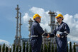 © eakgrungenerd - Industrial engineers shaking hands at oil refinery plant, symbolizing teamwork, safety and partnership in petroleum production. construction worker oil plant.