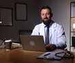 © New Africa - Doctor working on laptop at table in clinic during night shift