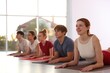 © New Africa - Group of teenagers and instructor practicing yoga on mats indoors, selective focus