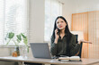 © PRIME STOCK LAB - Young woman on phone looking frustrated at home office desk with laptop notebook plant natural light